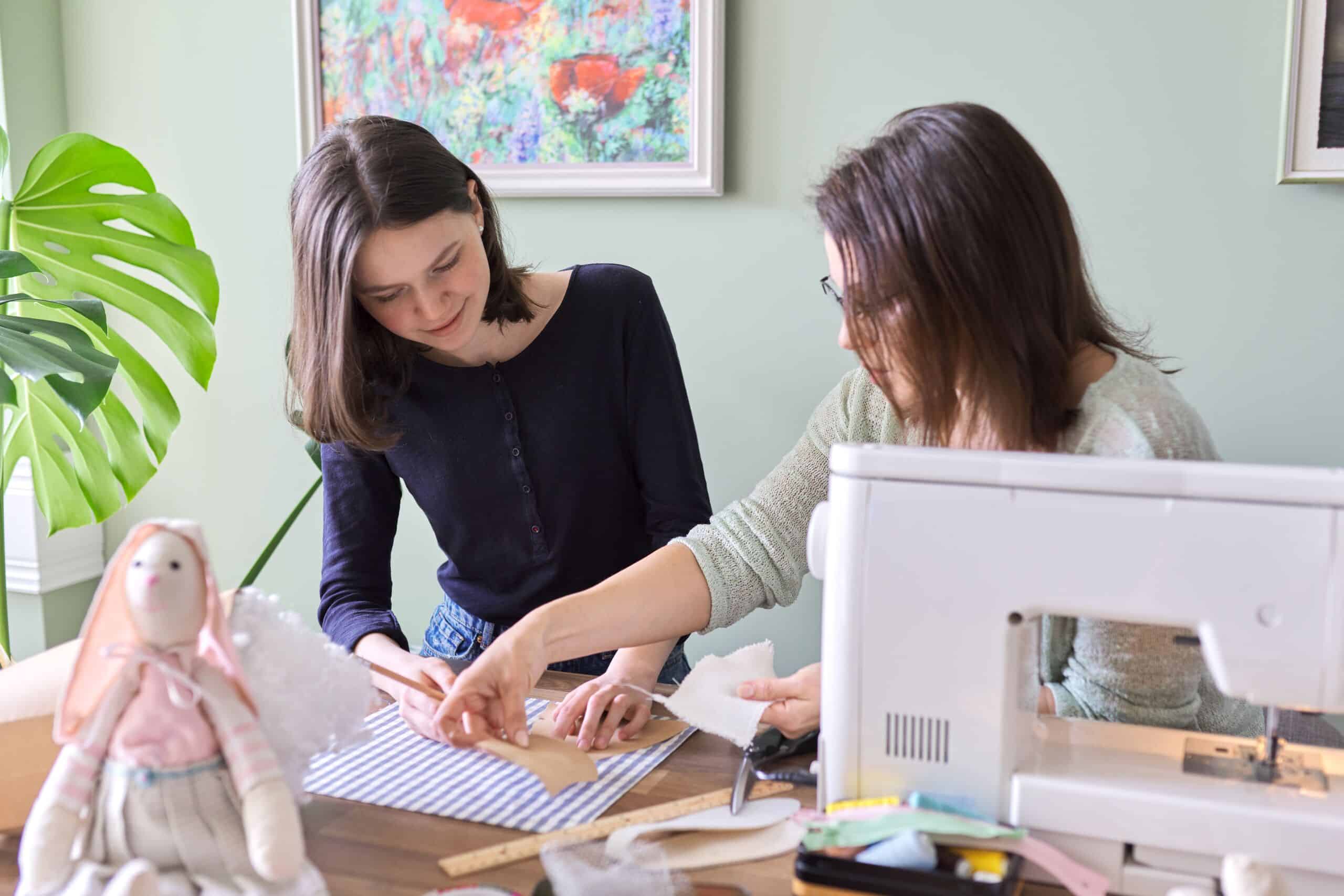 Mother and teen daughter sew together at home